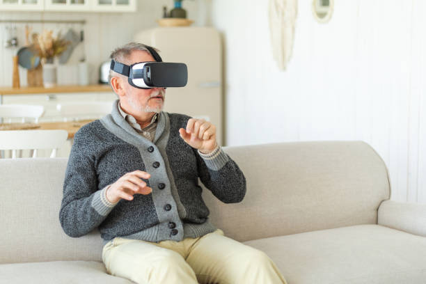 istock Excited mature senior man wearing using virtual reality metaverse VR glasses headset at home. Grandfather touching air during VR experience on virtual reality helmet. Simulation hi-tech videogame. 1489190150