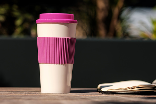 Still life photography of cup of coffee and book on a table outdoors. Old fashioned and retro-style concept. No technology. Imagination and creativity concept.