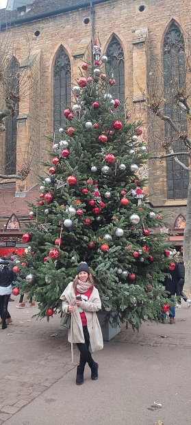 Image of a woman in front of a Christmas Tree in the village of Colmar