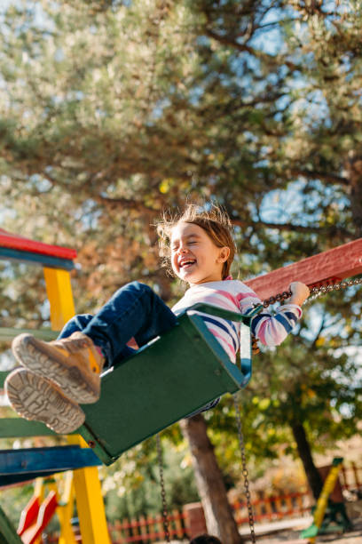 istock Cheerful little girl  having fun swinging 1489193934