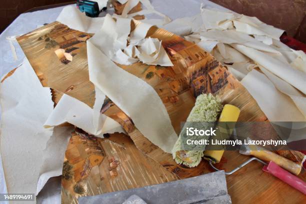 Rollers And A Spatula Lie On The Remains Of The Old Wallpaper During The Repair Stock Photo - Download Image Now