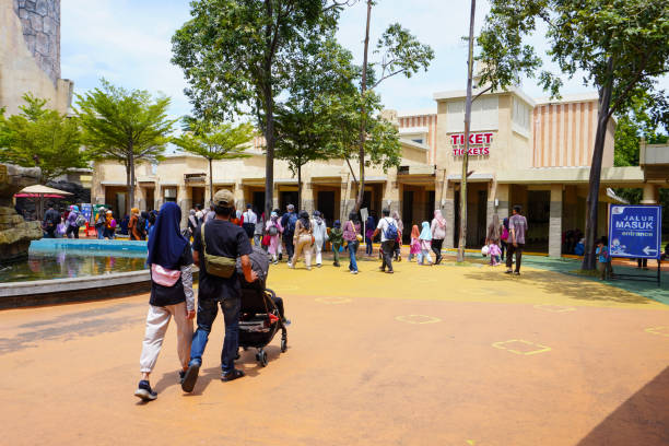 Crowds of visitors at the ticket entrance of Dunia Fantasi amusement park in Jakarta after pandemic restrictions lifted Busy ticket counters at Dunia Fantasi amusement park in Jakarta as visitors return after pandemic restrictions eased on January 22, 2023 roller coaster line photos stock pictures, royalty-free photos & images