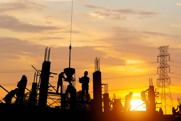 istock Silhouette of Engineer and worker team checking project at building site background, construction site with sunset in evening time background 1489201136