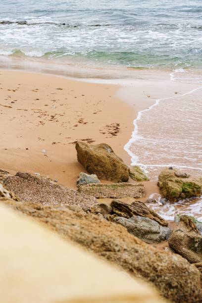 istock Sandy beach with rocks against the backdrop of tranquil waves. 1489201606