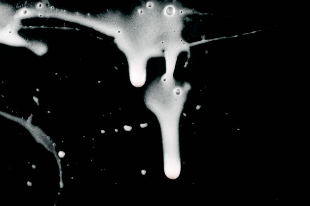 istock Streaks of white liquid on a black background. 1489202813