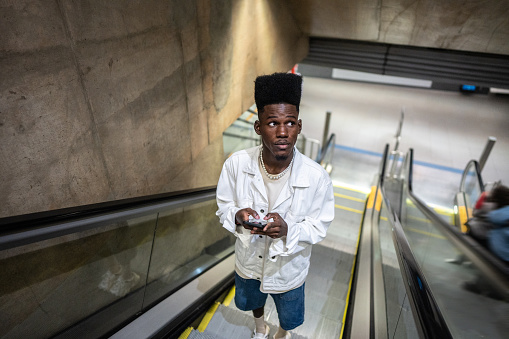 Young man using the mobile phone at the subway station