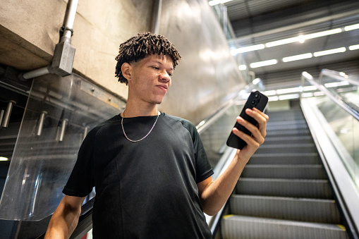 Young man using the mobile phone at the subway station