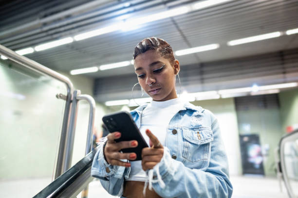 istock Young woman using the mobile phone at the subway station 1489203350