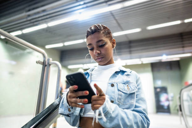 Young woman using the mobile phone at the subway station