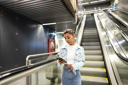 Young woman using the mobile phone at the subway station