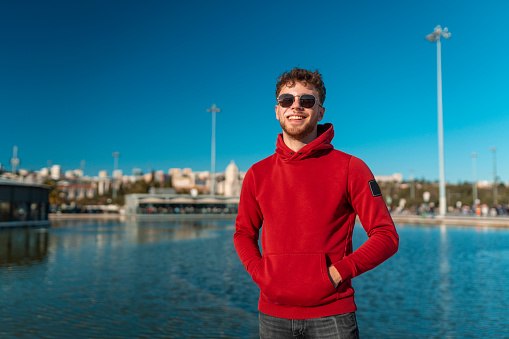 Young man with hands in pocket wearing warm clothes in winter in Lisbon, Portugal