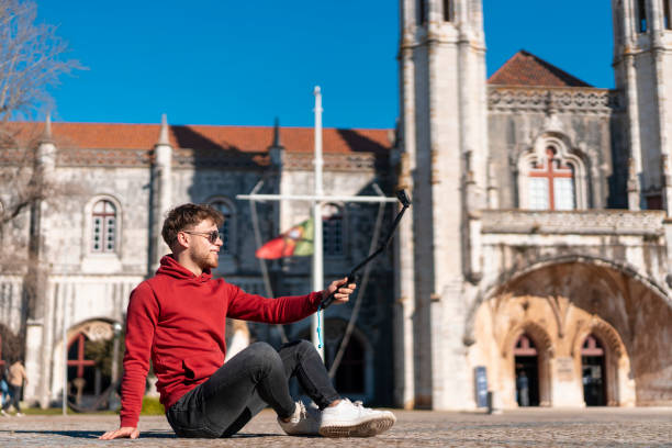 istock Man sitting on the floor vlogging outdoors 1489207295