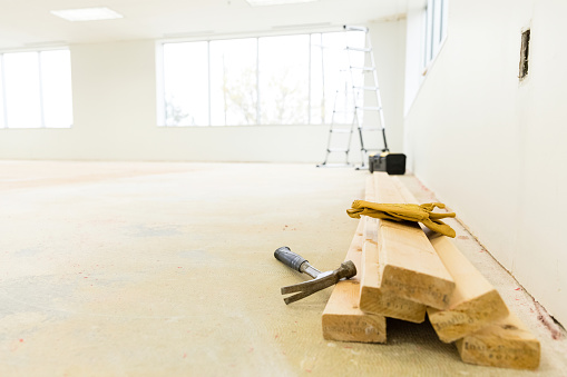 Low angle view of lumber, ladder and tools needed for the office space renovation.