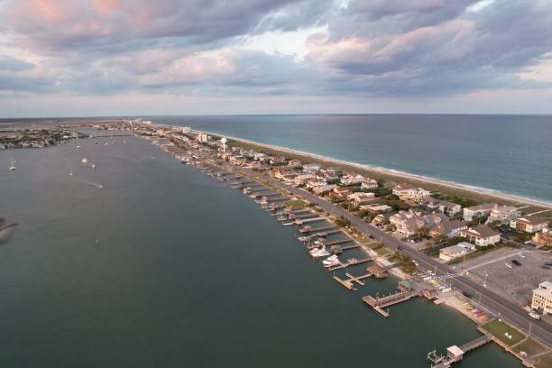 vistas aéreas de cima do extremo sul de wrightsville beach, carolina do norte ao pôr do sol. - south carolina beach south north carolina - fotografias e filmes do acervo