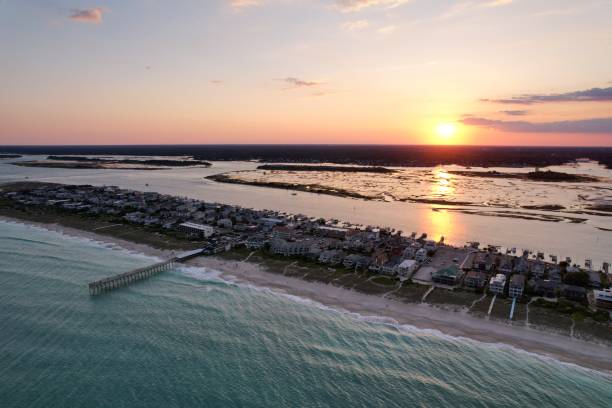 vistas aéreas de cima do extremo sul de wrightsville beach, carolina do norte ao pôr do sol. - south carolina beach south north carolina - fotografias e filmes do acervo