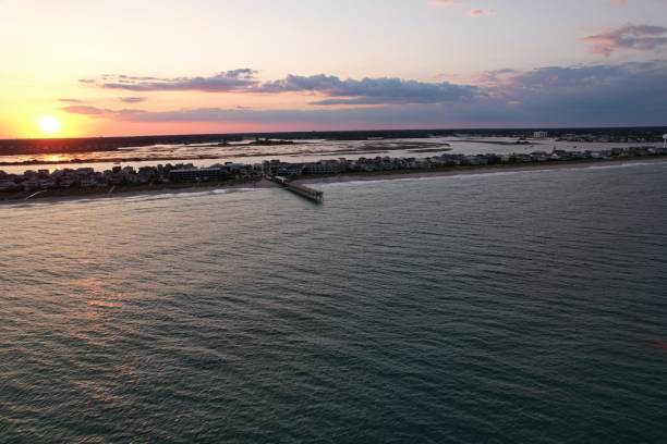 vistas aéreas de cima do extremo sul de wrightsville beach, carolina do norte ao pôr do sol. - south carolina beach south north carolina - fotografias e filmes do acervo