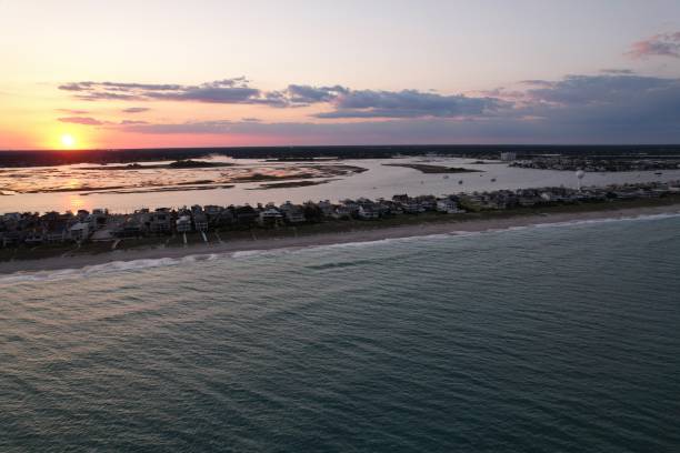 vistas aéreas de cima do extremo sul de wrightsville beach, carolina do norte ao pôr do sol. - south carolina beach south north carolina - fotografias e filmes do acervo