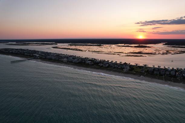 vistas aéreas de cima do extremo sul de wrightsville beach, carolina do norte ao pôr do sol. - south carolina beach south north carolina - fotografias e filmes do acervo