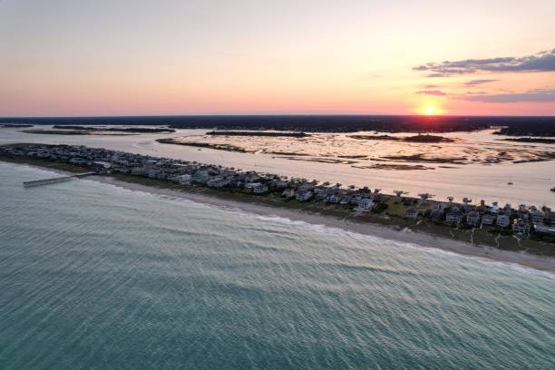 vistas aéreas de cima do extremo sul de wrightsville beach, carolina do norte ao pôr do sol. - south carolina beach south north carolina - fotografias e filmes do acervo