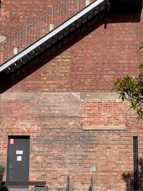 istock Tall red brick building illuminated by the sun on a bright summer day 1489211038
