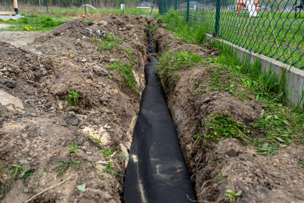 istock Drainage pipe wrapped in geotextile, inserted into a ditch dug around the house. 1489217930