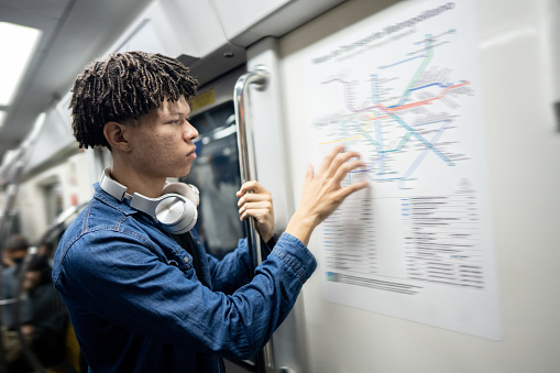 Young man looking at the map on the subway train