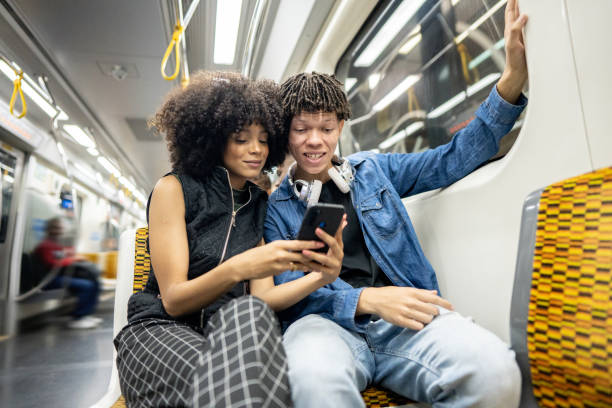 istock Friends using the mobile phone on the subway train 1489218836