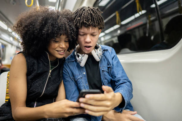 istock Friends using the mobile phone on the subway train 1489218841