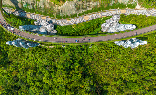Aerial view of the Golden Bridge in Ba Na hills, Da Nang, Vietnam. Lifted by two giant concrete hands. Iconic bridge in SunWorld resort and park