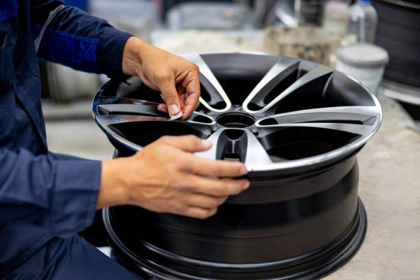 자동차 부품 공장에서 알로이 휠을 샌딩하는 남자의 클로즈업 - alloy wheel 뉴스 사진 이미지