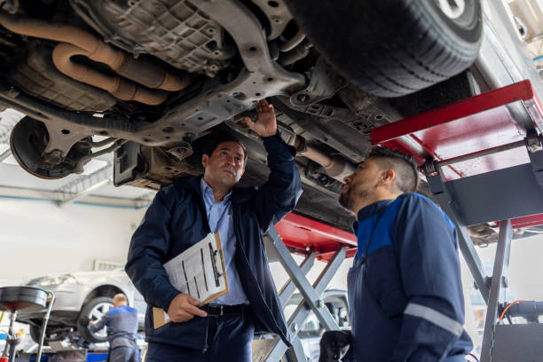 istock Foreman supervising the work of a mechanic while fixing a car 1489227473