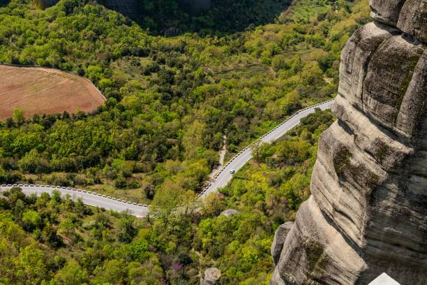 istock Winding road snaking down a steep hillside, alongside a lush, green valley. Kalabaka, Greece. 1489231289