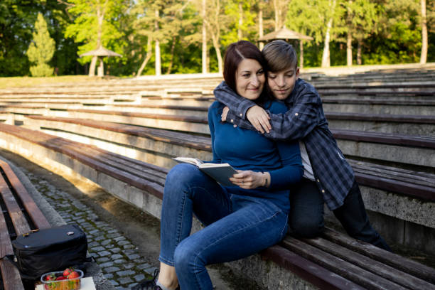 istock Mother and her son reading book in the public park 1489232971