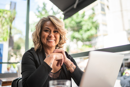 Portrait of a mature businesswoman using the laptop in a restaurant or coffee shop