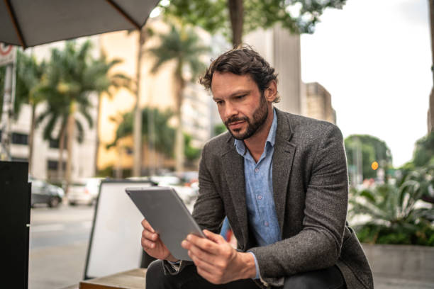 Mature man using the digital tablet in the street