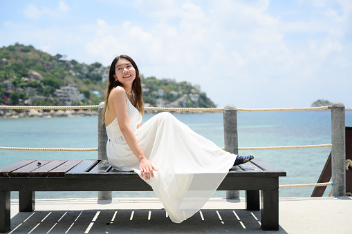 Happy traveler woman with white dress enjoying with beautiful view on beach, Woman travel on Koh Tao Islands in Thailand, Famous tourist attractions, Popular tourist destinations, Summer travel