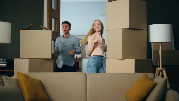 istock Couple dancing new apartment between packed boxes. Family moving in flat. 1489240128