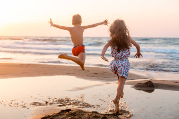 istock Cheerful children playing on the beach on a beautiful sunset 1489240603