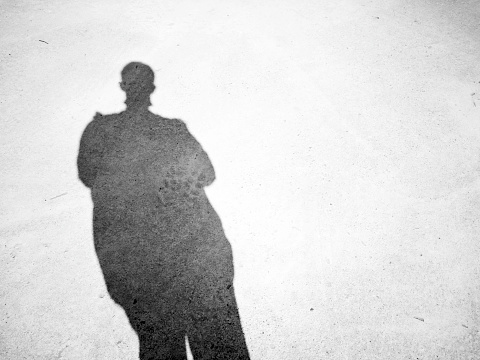 Shadows and silhouettes of a man on the ground. Shadow of a man on the ground texture. Shadow of a man on street concrete background with place your text.