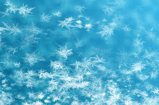 Frosty pattern on window in winter season. Abstract frosty pattern on glass. frosted glass texture. Blue foil freeze gradient texture background. The frozen water. Winter and Snow background. Frost texture iced surface, Winter material. Turquoise Frost Background.