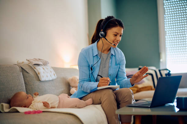 istock Stay at home mother talking during conference call over laptop. 1489251507