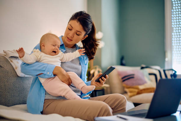 istock Upset baby crying while her mother is working at home. 1489251508