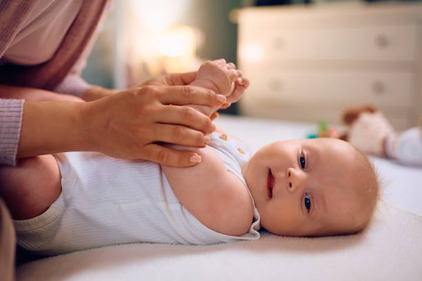 istock Cute baby lying down on bed while being with her mother at home 1489253122