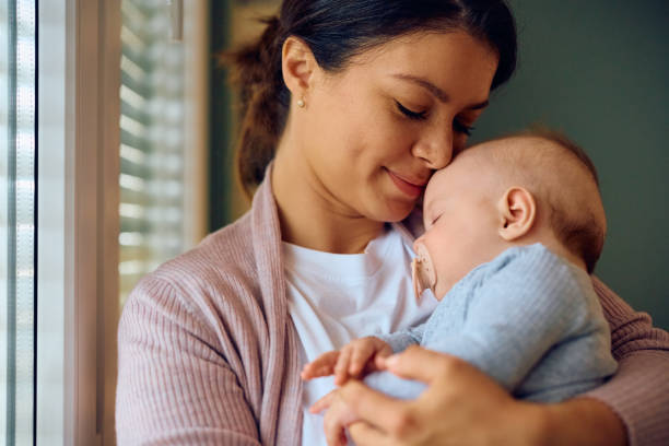 istock Young loving mother holding her sleeping baby at home. 1489253146
