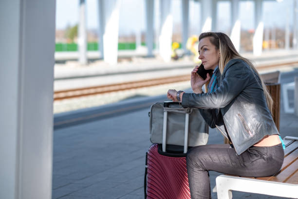 istock a woman is sitting on a bench waiting for a train 1489253650