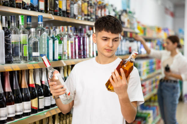 istock man chooses between vodka and cognac in  supermarket 1489258850