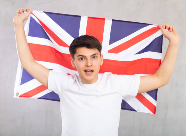 istock Surprised young guy holding UK flag 1489259579