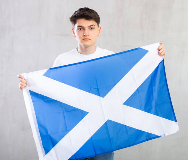 istock Focused young guy holding flag of Scotland 1489259639