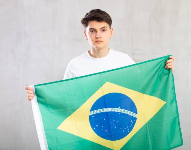istock Focused young guy holding flag of Brazil 1489259646