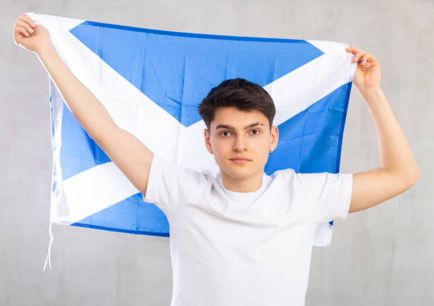 istock Focused young guy holding flag of Scotland 1489259655